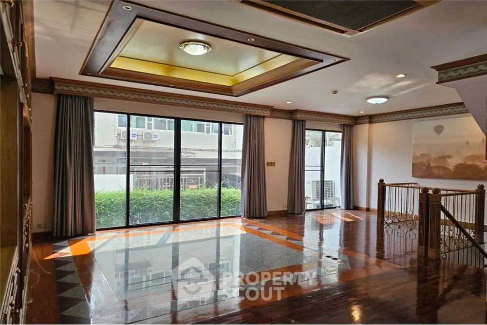 Spacious interior with large windows and polished wooden floors in a modern building.