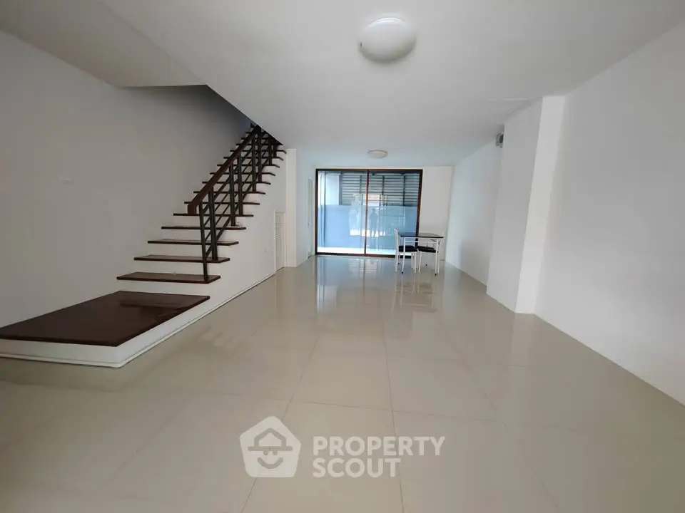 Spacious modern living room with sleek staircase and large windows