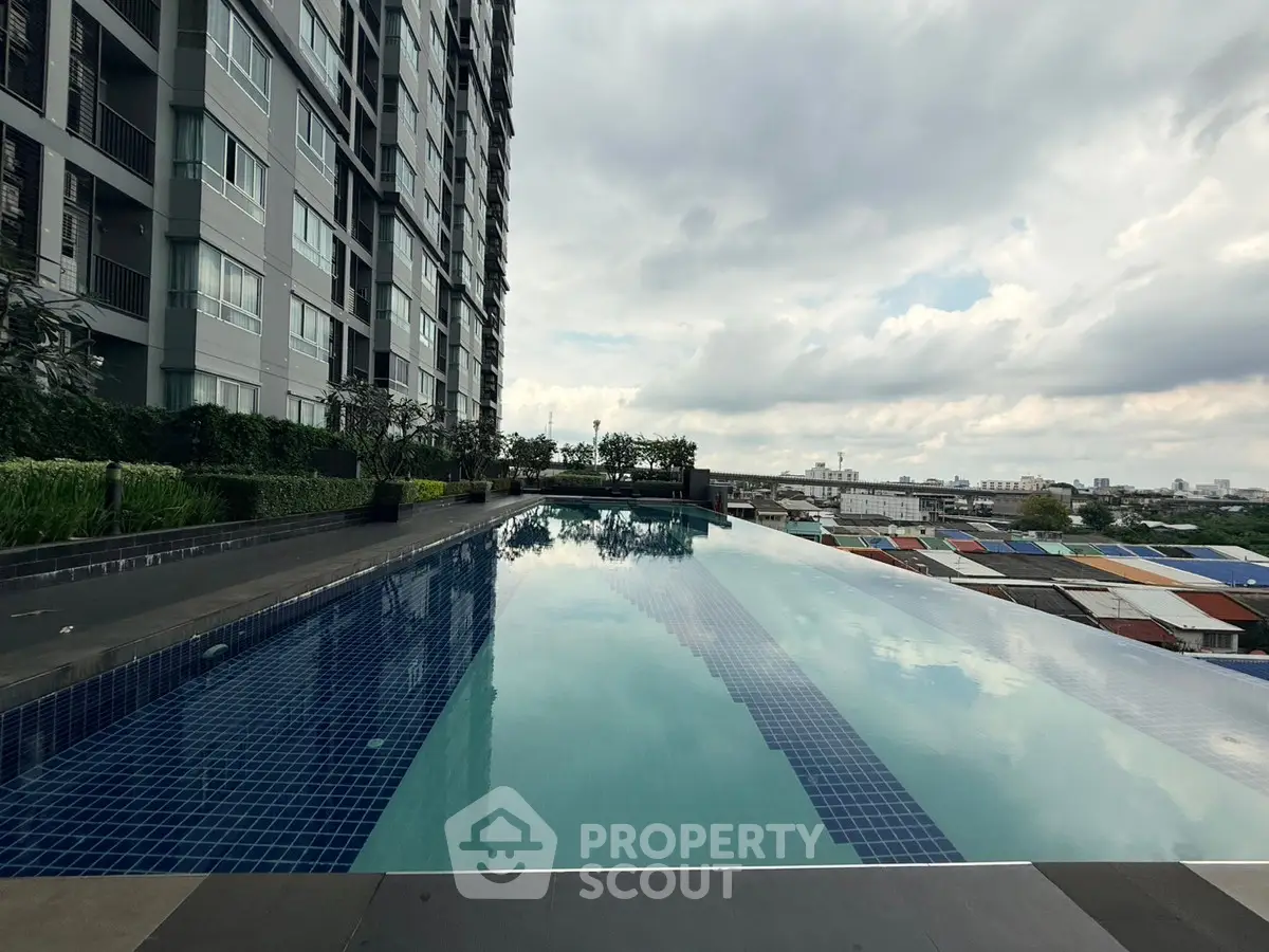Luxurious high-rise building with stunning infinity pool and cityscape view.