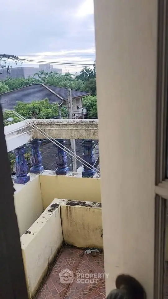 Charming balcony view with rustic railing and lush greenery