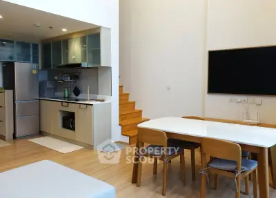 Modern open-plan kitchen and dining area with wooden flooring and sleek appliances.