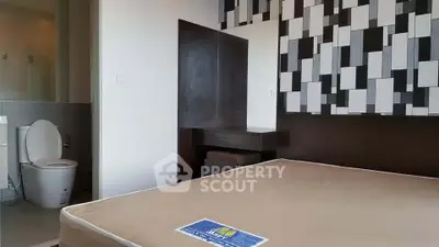 Modern bedroom with stylish decor and ensuite bathroom in a contemporary apartment.