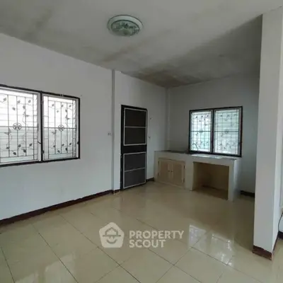 Spacious unfurnished room with tiled floor and large windows, ideal for customization.