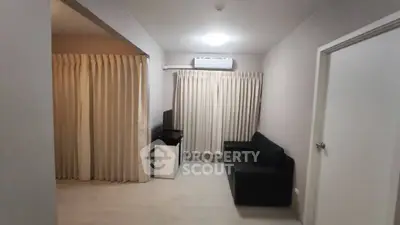Cozy living room with modern sofa and air conditioning, perfect for relaxation.