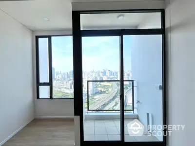 Modern apartment with stunning city view from balcony, featuring large windows and sleek design.