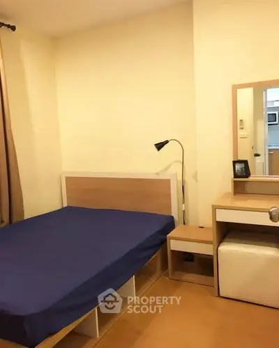 Cozy bedroom with modern furniture and blue bedding in a stylish apartment.