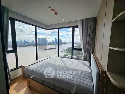 Stunning corner bedroom with panoramic river view in modern high-rise apartment.