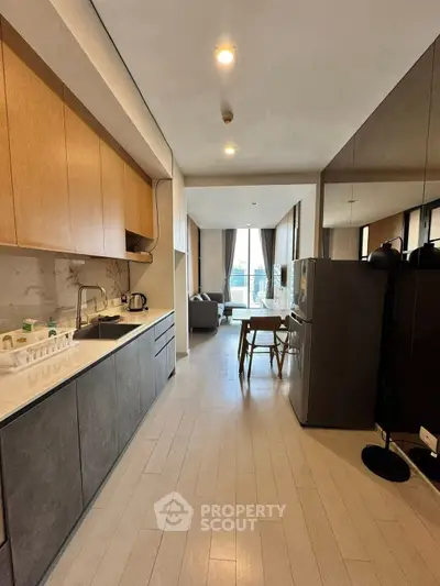 Modern open-layout kitchen with sleek cabinetry and spacious living area, featuring floor-to-ceiling windows.