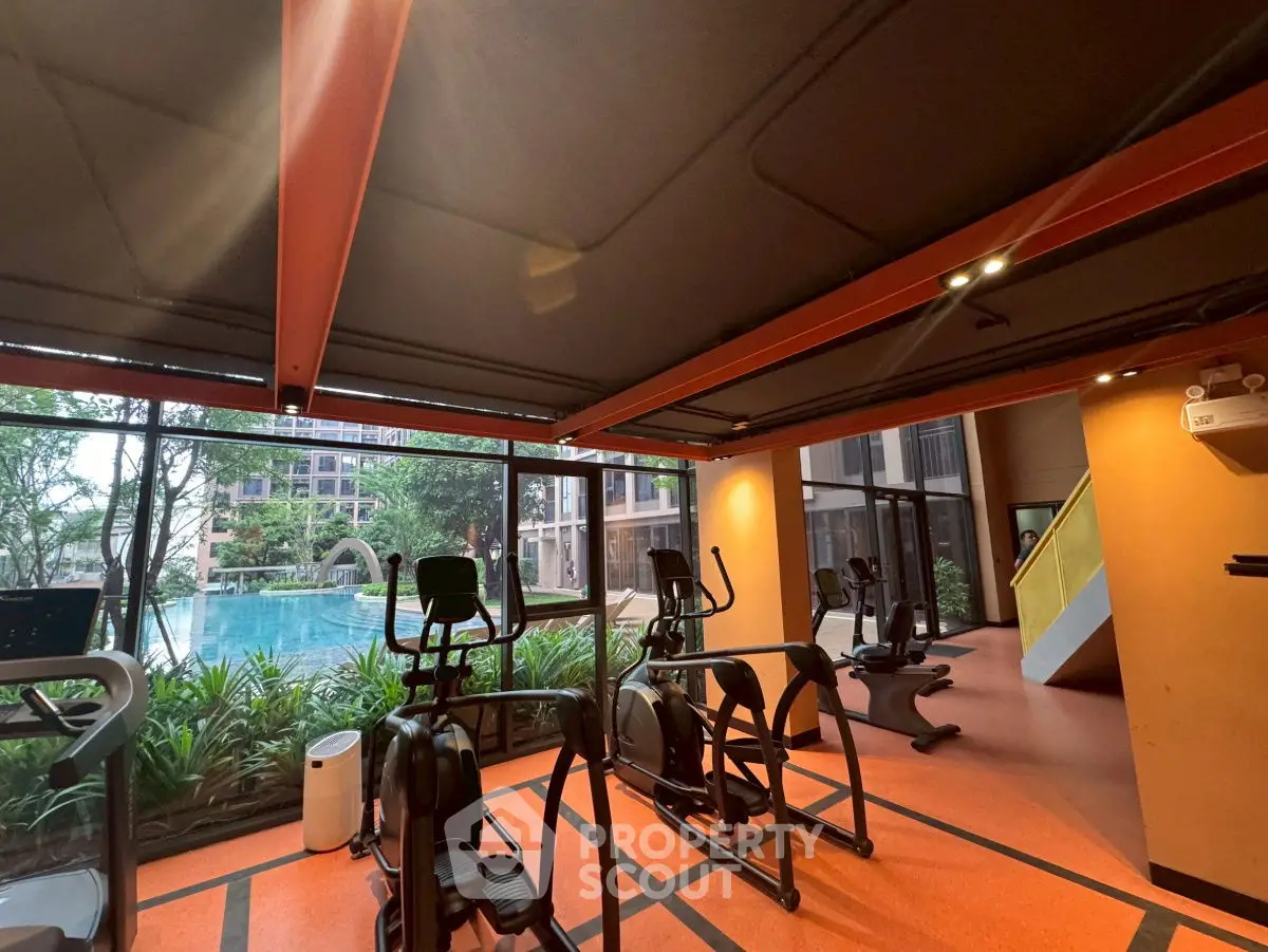 Modern gym with pool view in luxury residential complex