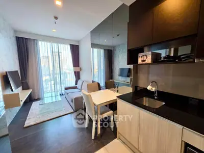 Modern living room with open kitchen and large windows in a stylish apartment.
