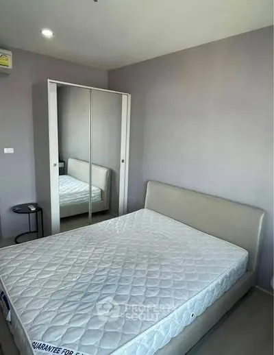 Modern bedroom with mirrored wardrobe and comfortable bed in a stylish apartment.