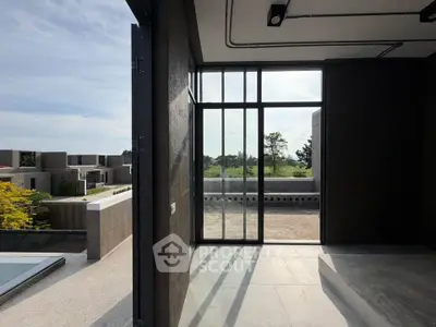 Modern architectural design with large windows and scenic view from a spacious balcony.