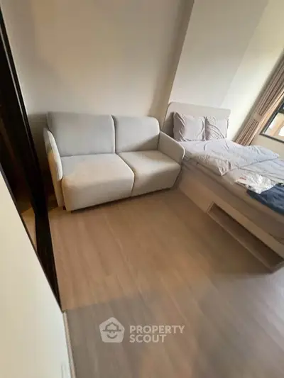 Cozy bedroom with modern sofa and stylish bed, perfect for relaxation and comfort.