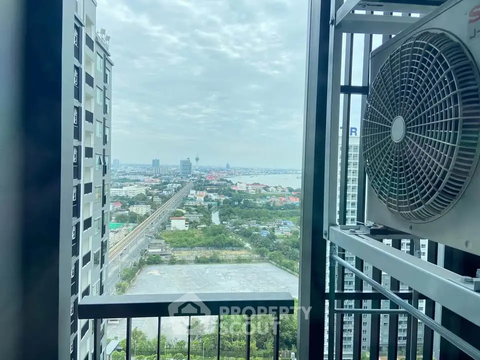 Stunning high-rise balcony view with cityscape and distant ocean horizon.