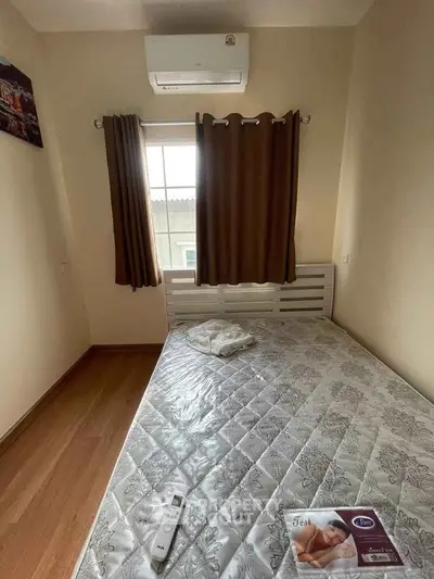 Cozy bedroom with air conditioning and wooden flooring, perfect for restful nights.