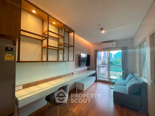 Modern living room with city view, featuring sleek furniture and large windows for natural light.
