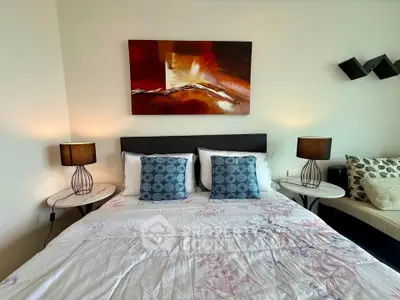 Modern bedroom with stylish decor and cozy ambiance, featuring elegant lamps and contemporary artwork.