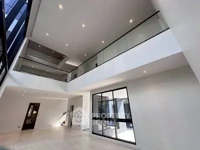 Stunning modern living room with high ceilings and glass balcony, perfect for luxury living.