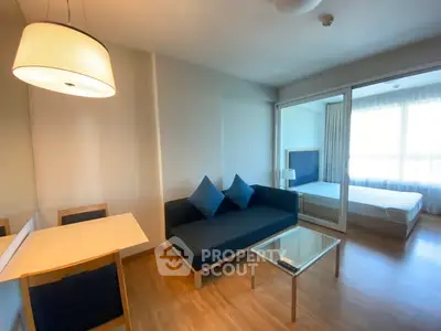 Modern living room with blue sofa and glass coffee table in bright apartment