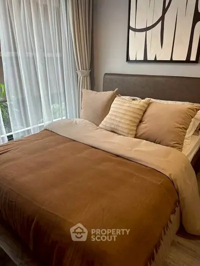 Cozy bedroom with elegant decor and large window for natural light.