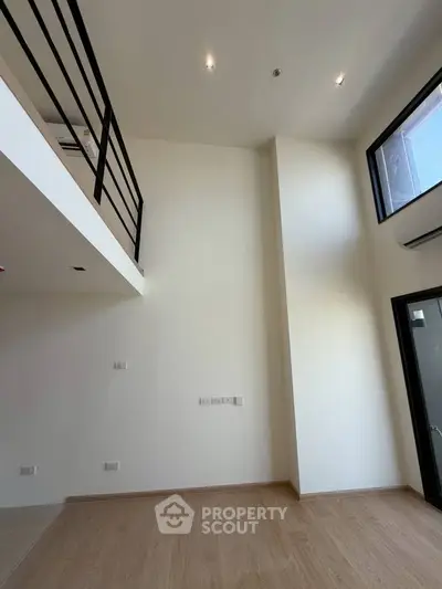 Spacious modern loft with high ceilings and large windows, perfect for natural light and open living.