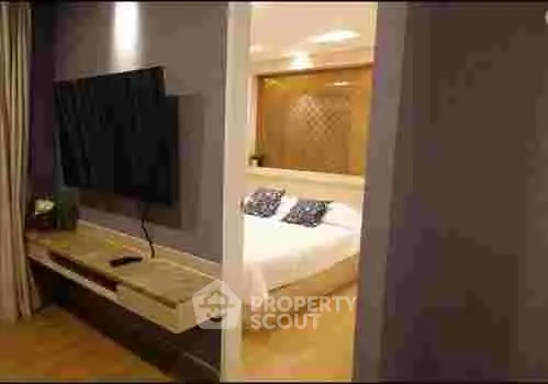 Modern bedroom with wall-mounted TV and cozy lighting