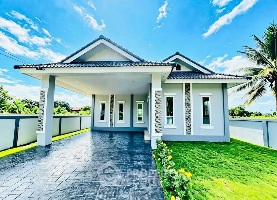 Stunning modern house with spacious driveway and lush green lawn under a clear blue sky.