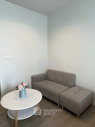 Cozy living room with modern gray sofa and stylish round coffee table, perfect for relaxation.