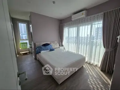Bright and airy bedroom with large windows and modern decor in a stylish apartment.