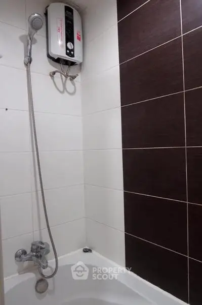 Modern bathroom with shower and water heater, featuring sleek tile design.