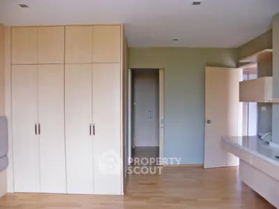 Spacious bedroom with built-in wooden wardrobe and desk