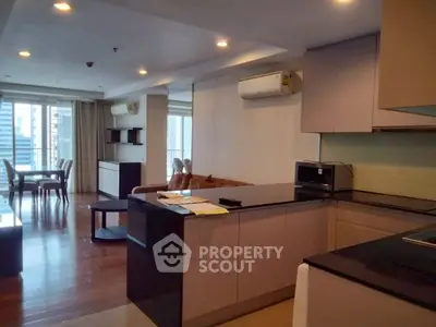 Spacious open-plan living room with modern kitchen and dining area, featuring city views.