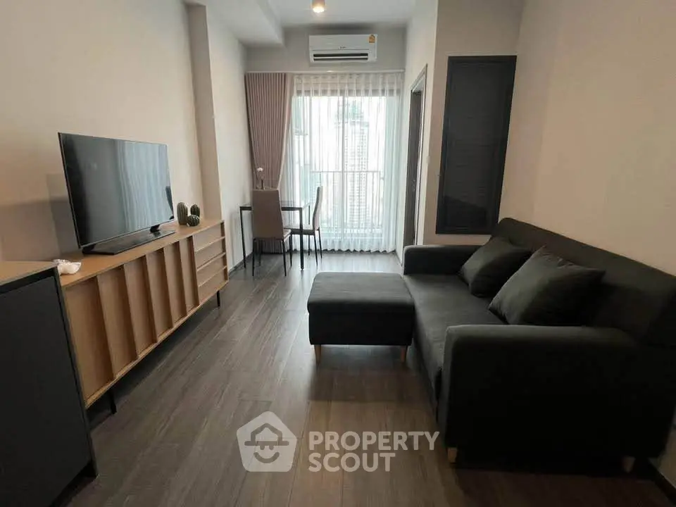 Modern living room with sleek furniture and large window in a stylish apartment.