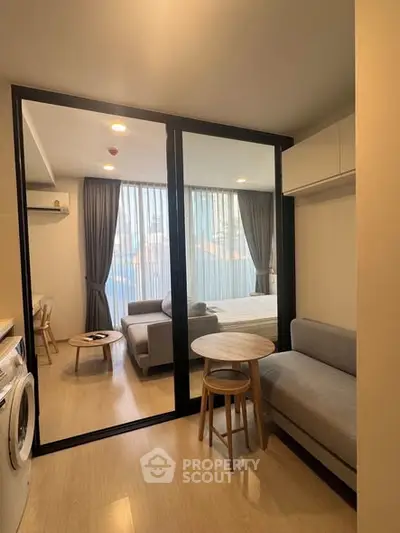Modern studio apartment with open layout, featuring cozy living area and stylish furniture.