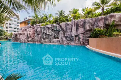 Luxurious resort-style swimming pool with tropical landscaping and rock formations.