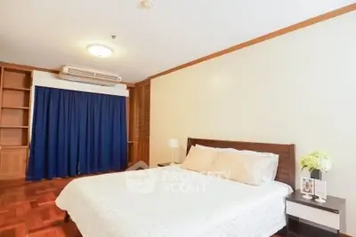 Spacious bedroom with elegant wooden flooring and cozy ambiance