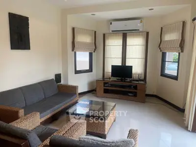 Cozy living room with wicker furniture and air conditioning, perfect for relaxation.