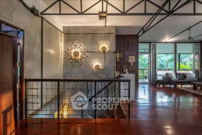 Stunning open-layout living area with modern decor and lush garden view, featuring polished wooden floors and stylish lighting.