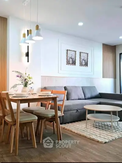 Modern living room with stylish decor, cozy sofa, and elegant dining area in open layout.