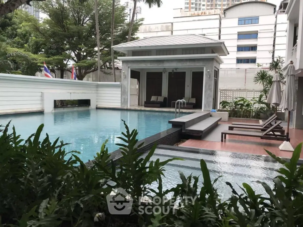 Luxurious residential pool area with modern design and lush greenery