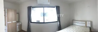 Cozy bedroom with large window and modern air conditioning unit, perfect for comfortable living.