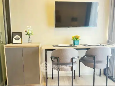 Modern dining area with wall-mounted TV and stylish chairs in a cozy apartment.