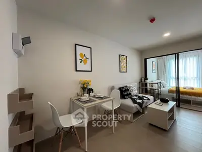 Modern living room with dining area and cozy bedroom in open layout apartment