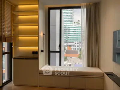 Modern living room with built-in seating and city view, featuring sleek shelving and large windows.