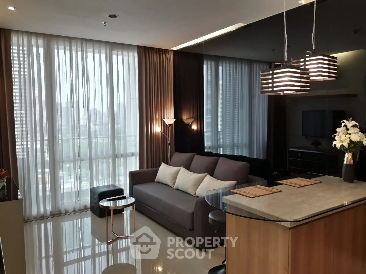 Modern living room with stylish lighting and large windows in a high-rise apartment.