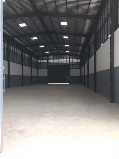 Spacious industrial warehouse with high ceilings and ample natural light.