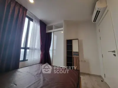 Modern bedroom with large window and air conditioning in a stylish apartment.