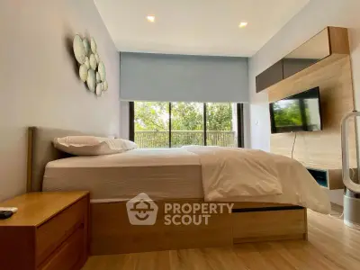Modern bedroom with large window and stylish decor, featuring a comfortable bed and wooden furniture.
