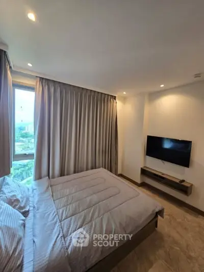 Modern bedroom with large window and wall-mounted TV, offering a cozy and inviting atmosphere.