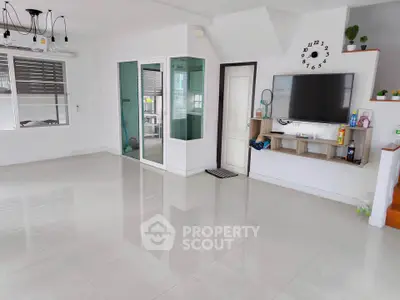 Spacious modern living room with sleek tile flooring and wall-mounted TV